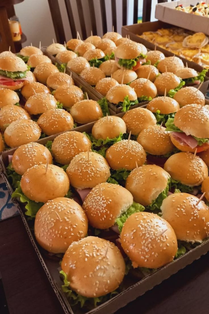 Large catering trays of mini burger sliders prepared for an event